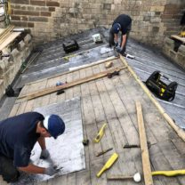 Image showing two of our Lead Workers measuring the Bay lengths ready to boss up and install the new Sandcast lead to the Chancel Roof