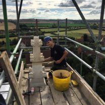 Image showing Tom one of our Apprentices pointing one of the newly fixed Pinnacles