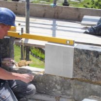 Image of one of our stonemasons installing the new battlement stones with the existing areas we were able to work with