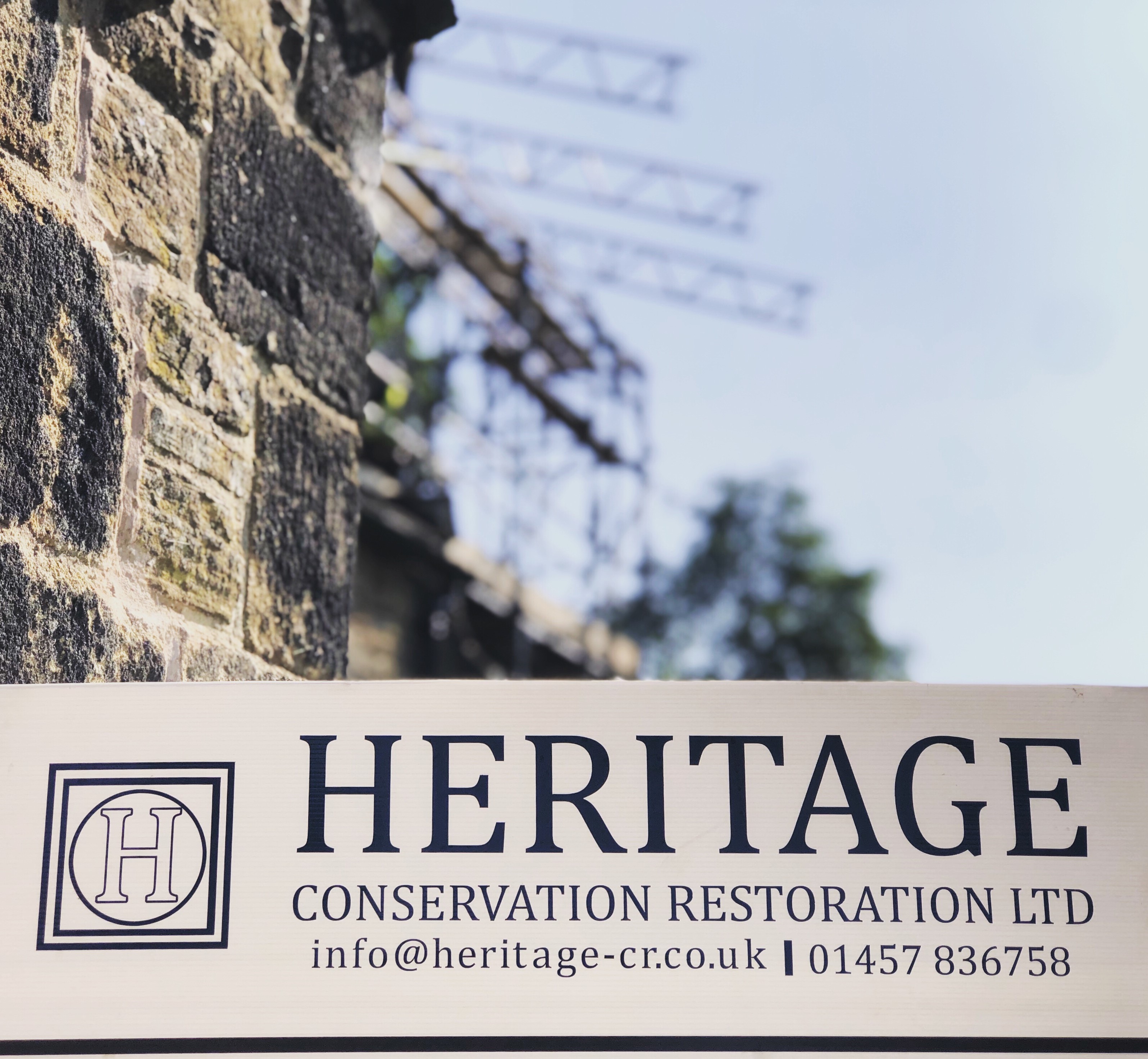 Heritage sign in the foreground, with temporary roof scaffold beiing installed in the background